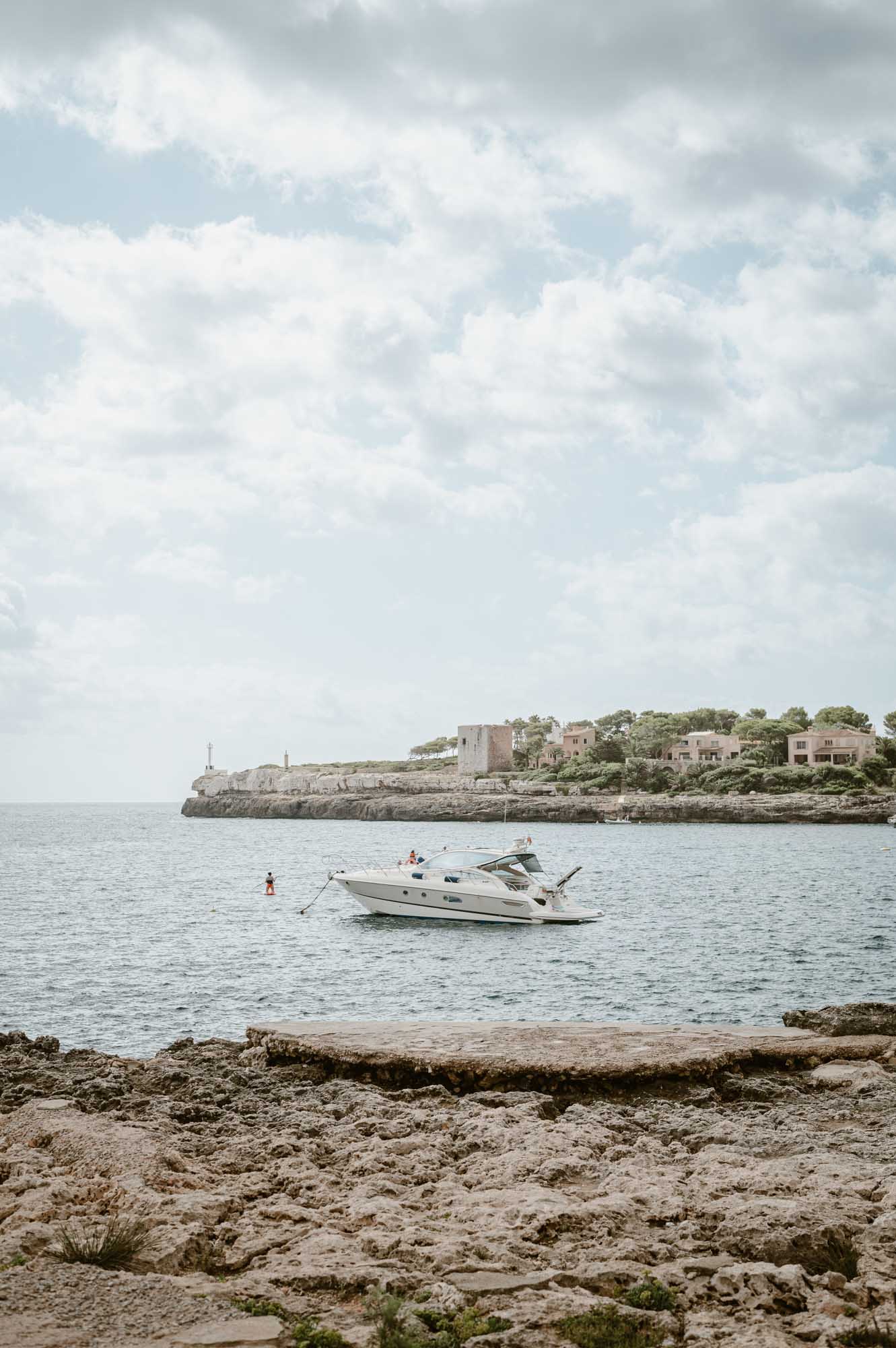 Panoramic view on the ocean with a boat in the neighborhood of Cala D'Or beach in Palma de Mallorca.