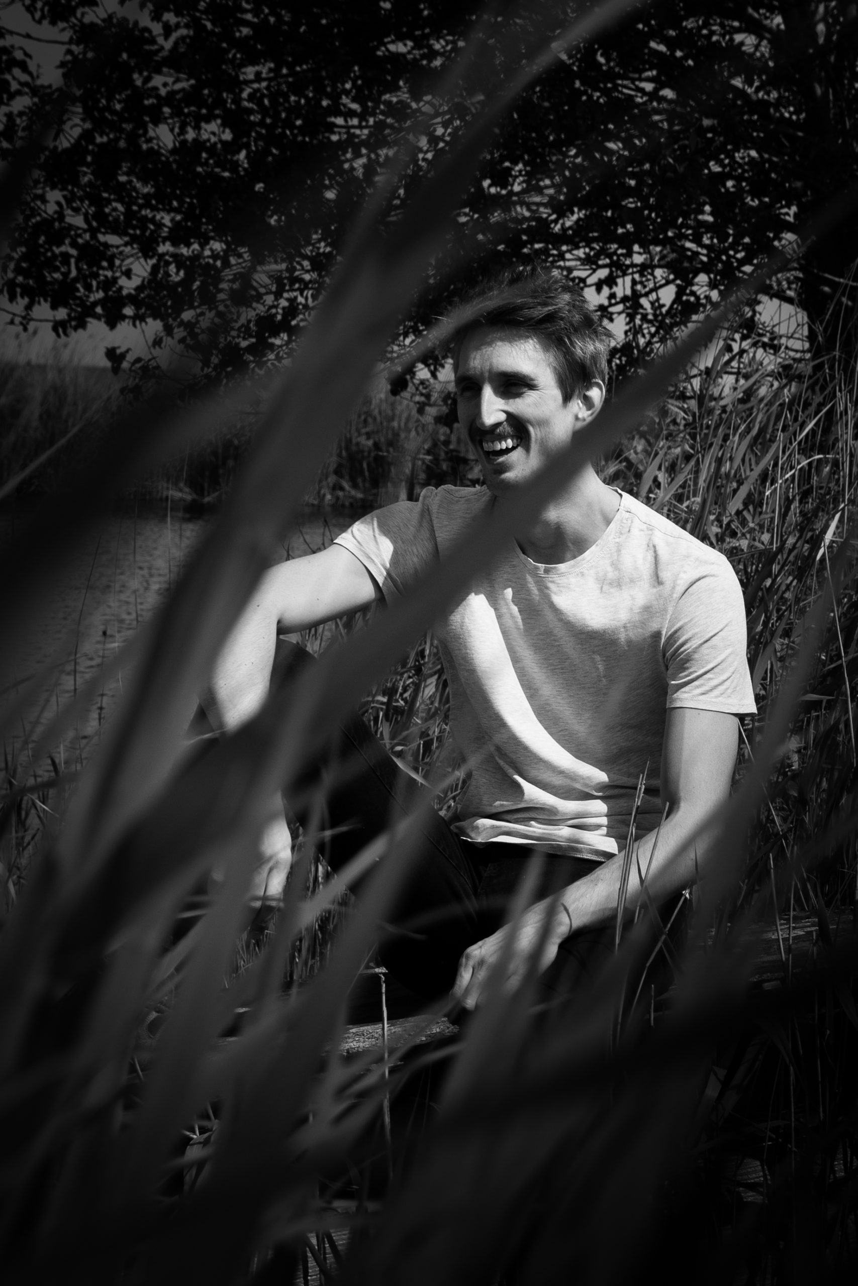 Black and white portrait of a smiling man in nature